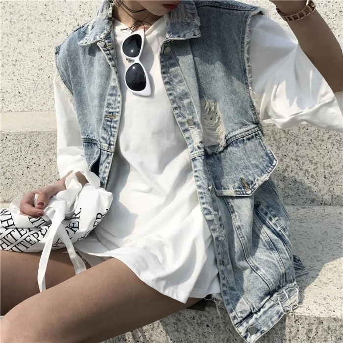 vest in pale blue, acid weash denim, with a long design, featuring pockets and rips, 90s grunge fashion, over a white oversized t-shirt, worn like a mini dress, by a slim woman