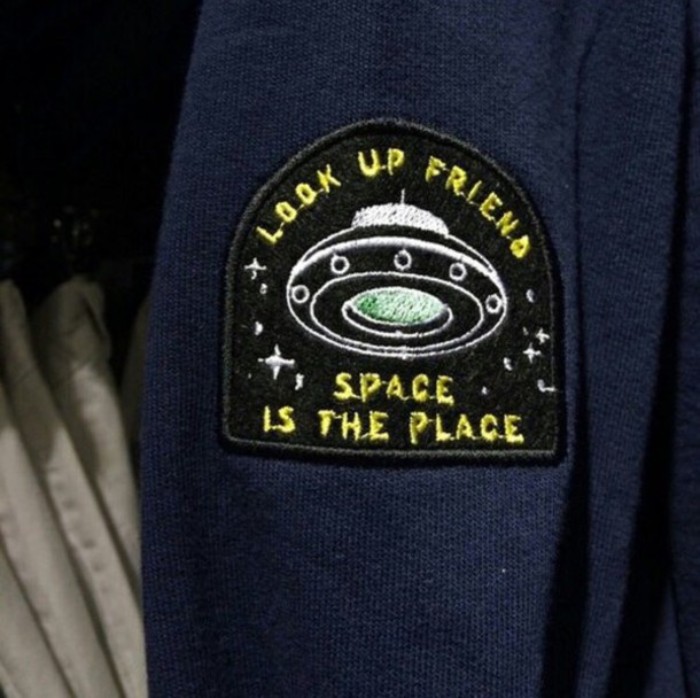 patch in black, featuring a flying saucer, and the words look up friend, space is the place, embroidered in white, yellow and pale green, 90s grunge accessories, sewn on a dark blue fabric