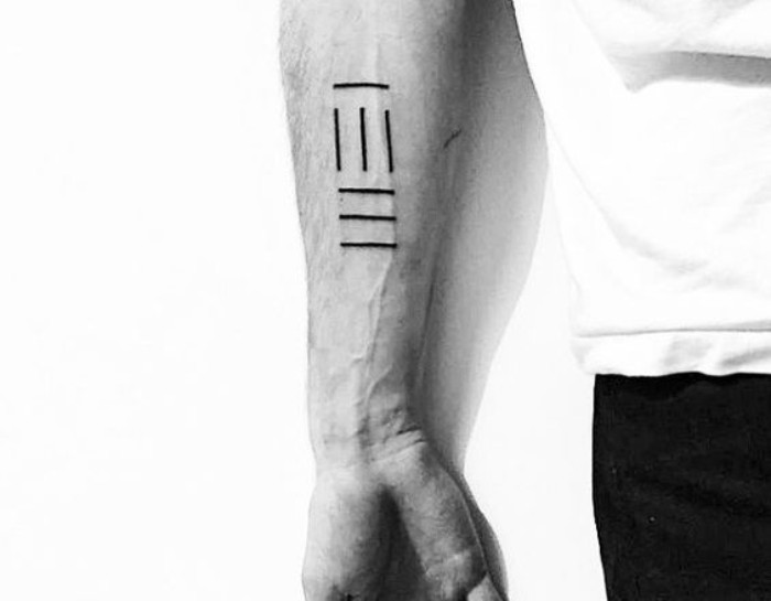 seven lines in black, tattooed on a man's lower arm, simple and minimalistic design, seen in a black and white photo, small symbolic tattoos for guys