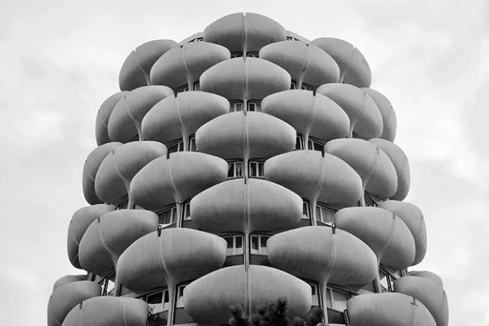 pod-like terraces made from grey concrete, attached to a tall building, types of brutalism, black and white image