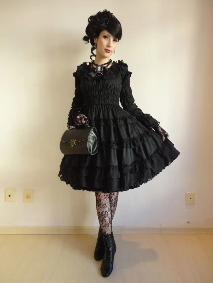 frilly black dress, with lace trims, worn over black, meshy sheer tights, with floral shapes, define lolita, on a young woman with black hair, and red lipstick