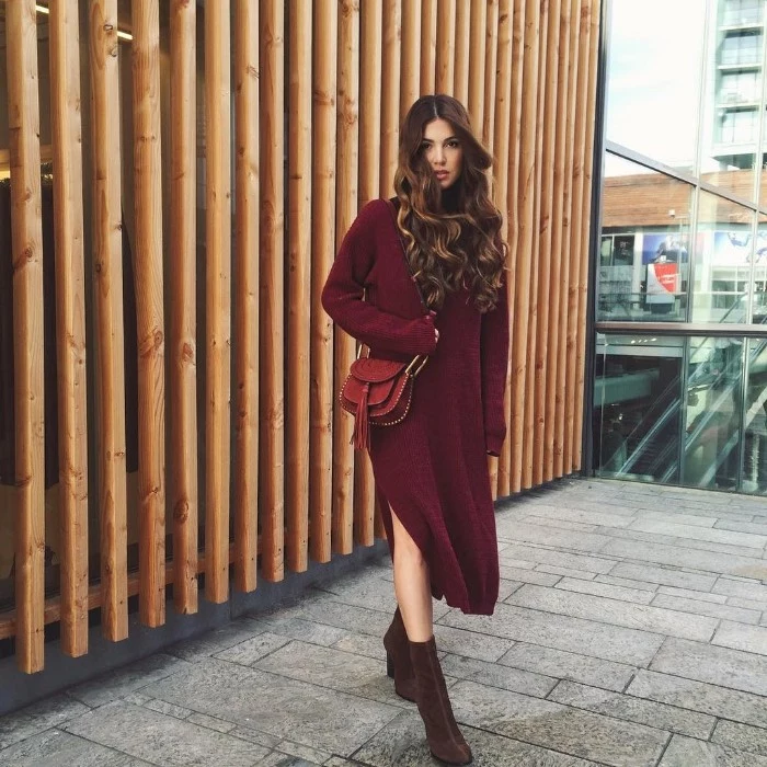 wine jumper dress, with a side slit, worn with dark brown sueded boots, and a brown leather bag, thanksgiving outfits, brunette woman with long curled hair