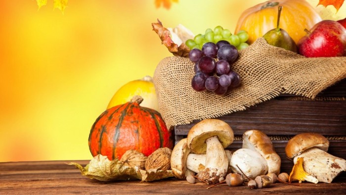 grapes and pears, apples and pumpkins, and several mushrooms, inside and next to a wooden crate, lined with burlap, thanksgiving card messages