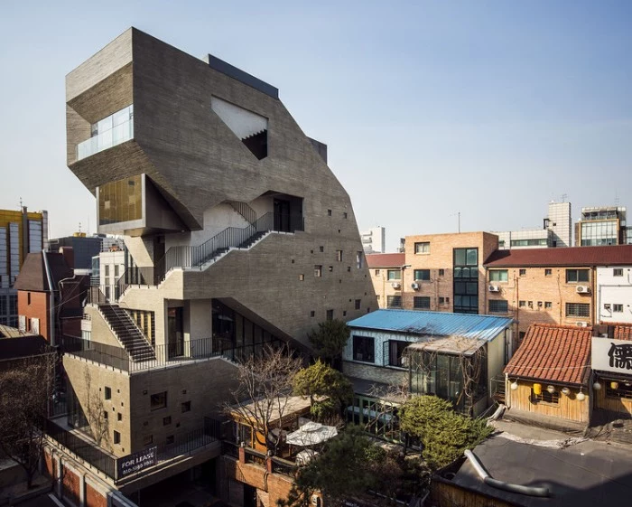 tall assymetrical building, with multiple staircases, terraces and windows in different sizes, concrete architecture around the globe