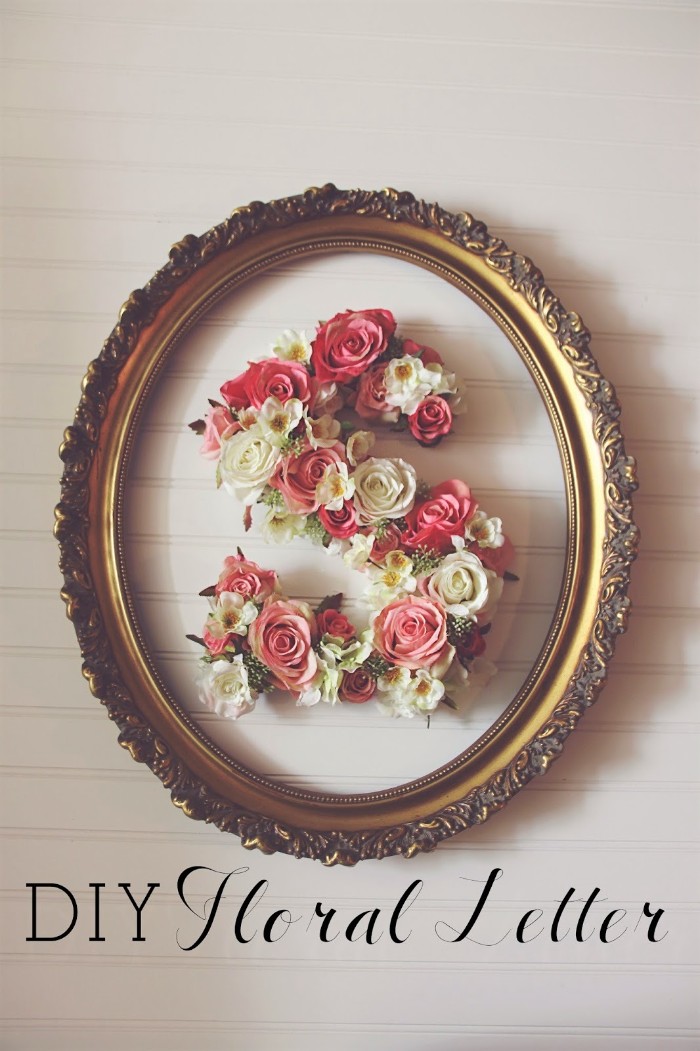 ornamental frame with an oval shape, painted in gold, containing the letter s, teenage girl room ideas, decorated with cream, and pink faux flowers