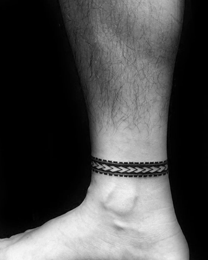 bracelet-like tattoo, with a chain pattern, going around a man's ankle, and done in black ink