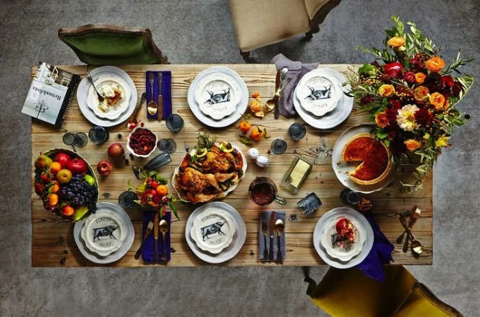 pie and turkey, fruit and butter, on a rectangular wooden table, set for six, seen from above, thanksgiving tablescape, bouquet with orange, red and yellow flowers