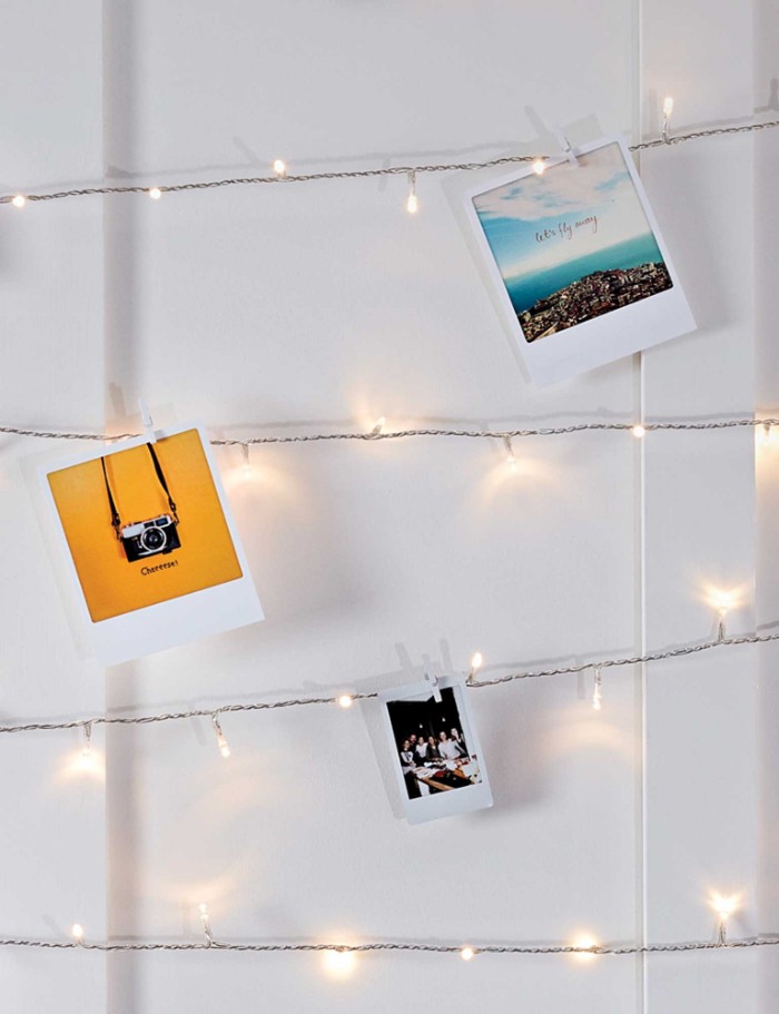 three colorful polaroid photos, attached to lit string lights, with smal clothes pegs, cheap ways to decorate a teenage girl's bedroom