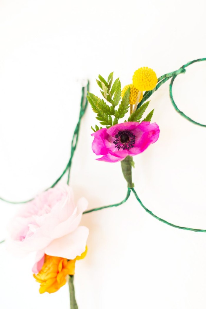 close up of purple, pale pink and yellow flowers, attached to a thin green wire, diys for girls, on a white background