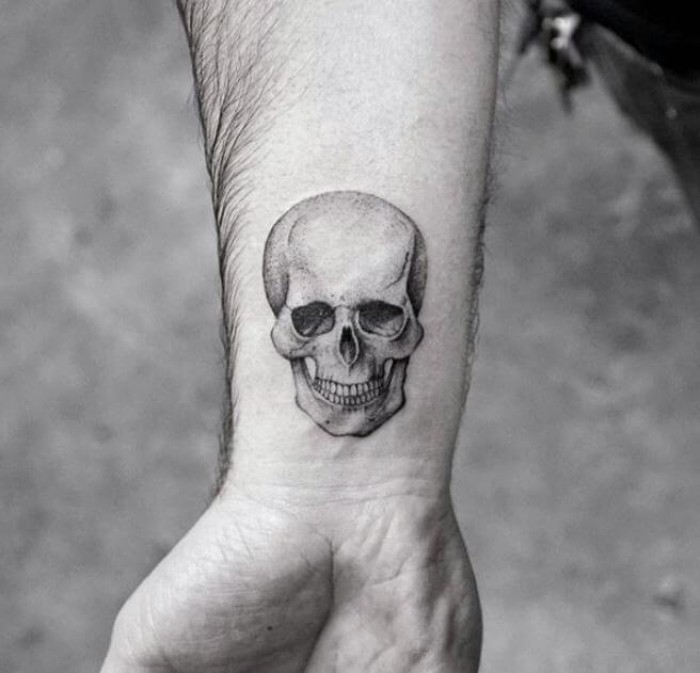 anatomically correct human skull, tattooed in black and grey, on a man's wrist, tattoos with deep meaning, memento mori, photo in black and white