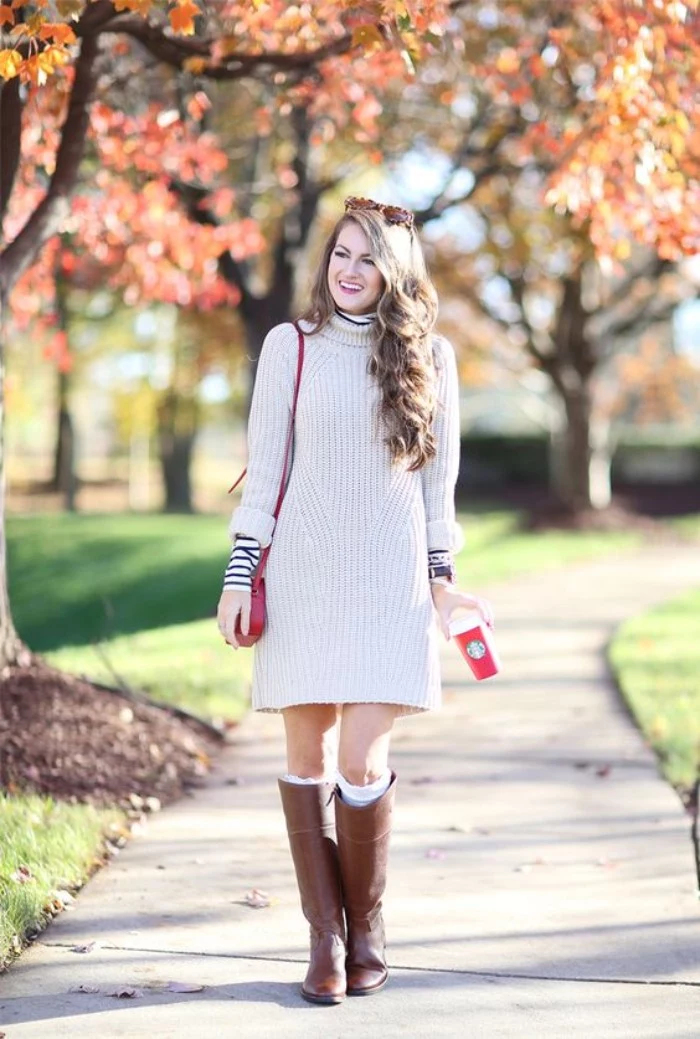off-white sweater dress, worn over a black and white, striped polo neck jumper, comfy outfits, on a smiling brunette woman, with tall brown leather boots