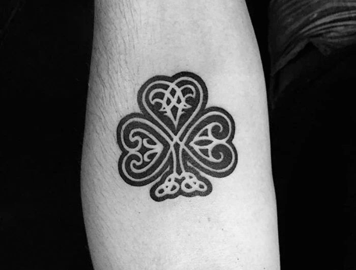 celtic symbol tattoo, shamrock in black and white, with decorative flourishes, lower arm tattoos, for irish guys