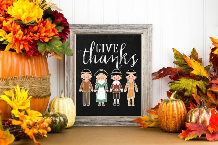 drawing featuring pilgrims and indians, with the words give thanks, on a blackboard, with a grey wooden frame, surrounded by fall-themed decorations