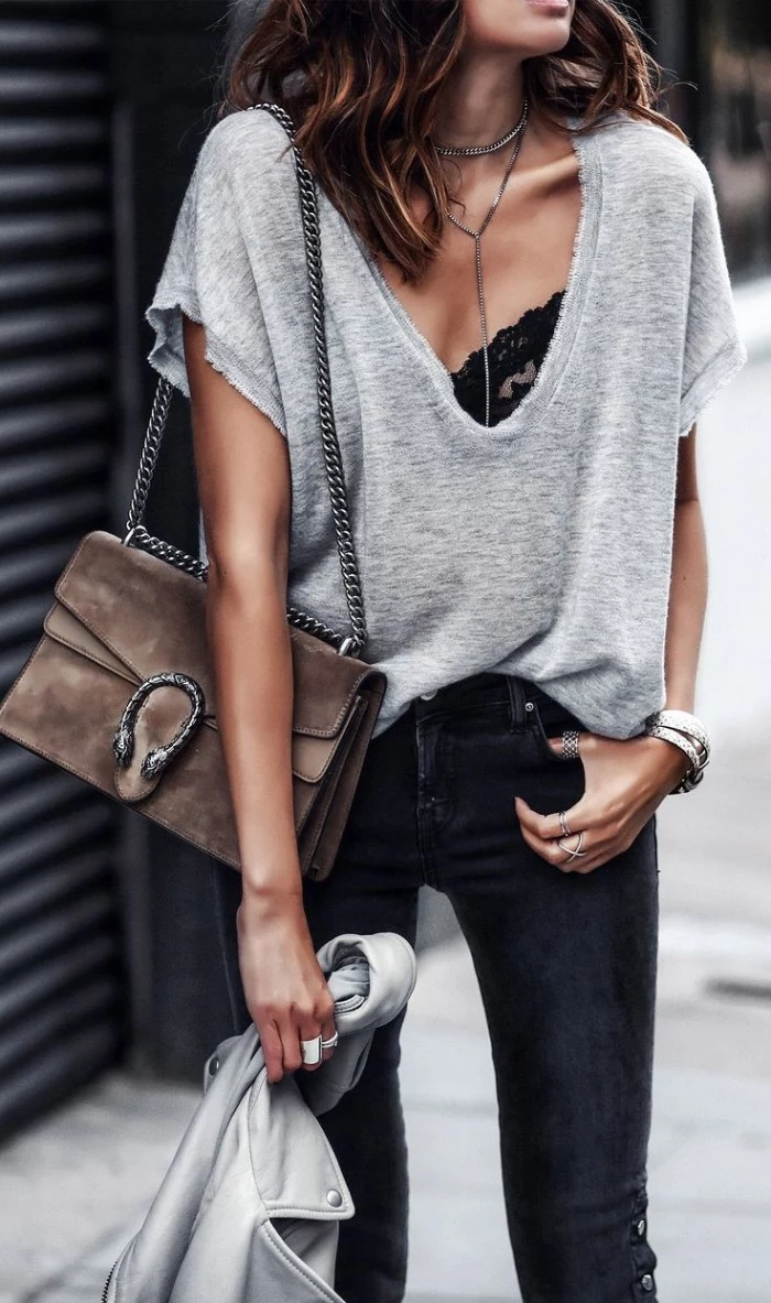 baggy pale grey v-neck t-shirt, worn over a black lace bralette, with dark grey skinny jeans, how to wear a bralette, on a brunette woman, carrying a pale brown, suede shoulder bag