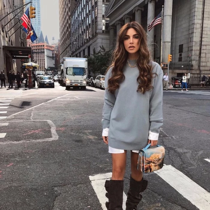 baggy and long, pale grey jumper, over an oversized white shirt, thanksgiving outfits for women, brunette woman with long hair, wearind tall suede, dark brown boots