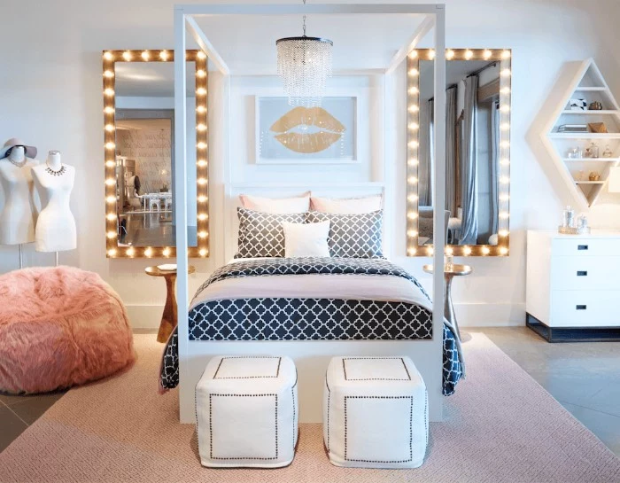 mirrors with illuminated frames, surrounding a bed, with a white frame, and black and white bedding, cool beds for teens, beige rug and a fluffy pink ottoman