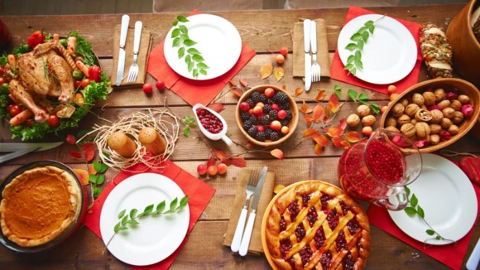 berries and walnuts, in wooden bowls, a roasted turkey and two pies, on a rustic wooden table, set for four, thanksgiving text messages with photos