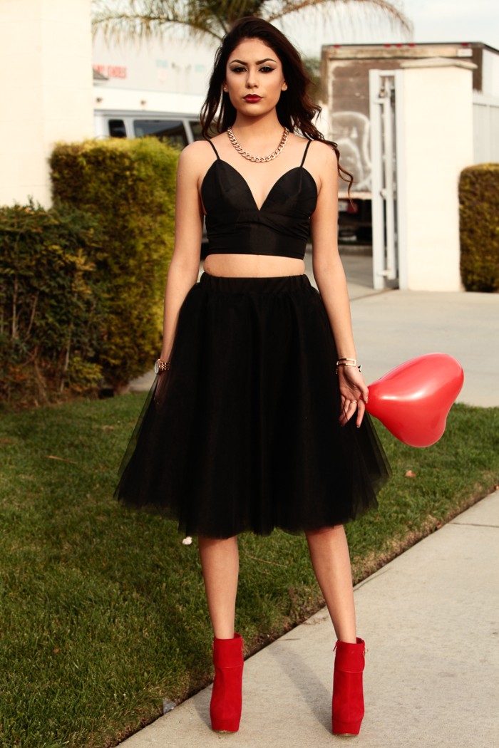 what to wear with a bralette, black tulle knee length skirt, combined with a blakc bralette, and red ankle boots