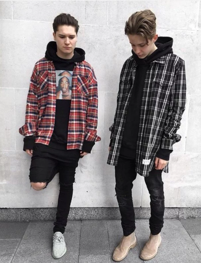 a pair of guys, standing side by side, dressed in black, ripped skinny jeans, and plaid shirts in different colors, over black hoodies