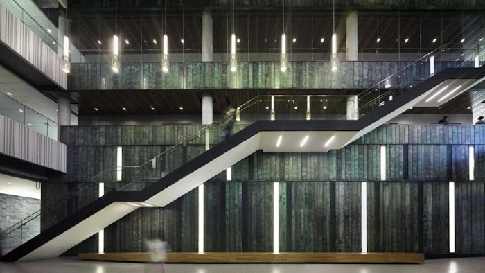 interior of the university of toronto's entry hall, brutalist art and architecture, big open plan space, with a large staircase, and multiple light sources