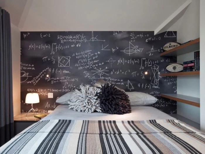blackboard covered in mathematical equations, written in white chalk, on one of the walls of a room, with a bed in grey and white, teenage bedroom ideas for small rooms