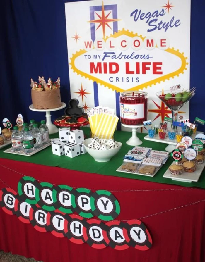 snack table with casino-themed canapes, decorated with a large poster, resembling the las vegas sign, reading welcome to my fabulous mid life crisis, 50th birthday party ideas for men, with lots of humor