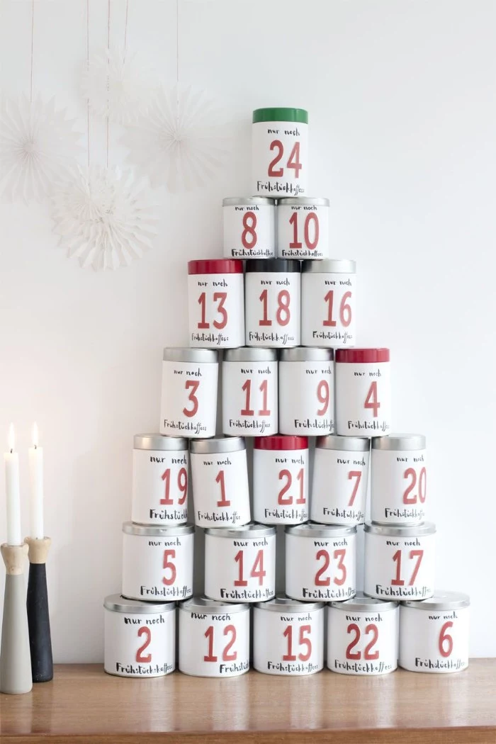 pyramid shape made of white cans, with silver and black, red and green details, fun advent calendars, each can features a number, from 1 to 24, written in red