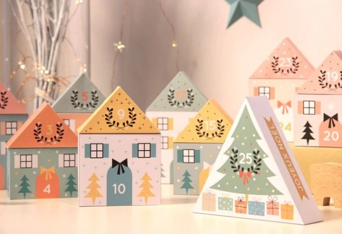 yellow and coral pink, light teal and white, miniature houses made of card, each is numbered, and decorated with christmas motifs, christmas countdown calendar, colorful idea for kids