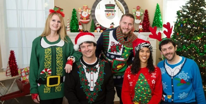 five smiling young people, wearing festive jumpers, in different colors and designs, santa's suit in green, mock tuxedo decorated with holly, ugly sweater ideas, xmas tree and snowflakes