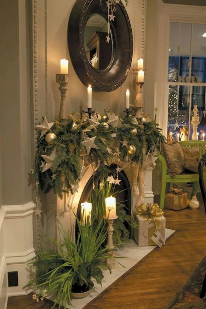 laminate flooring near a fireplace, decorated with pine garlands, silver star-shaped ornaments, and burning candles