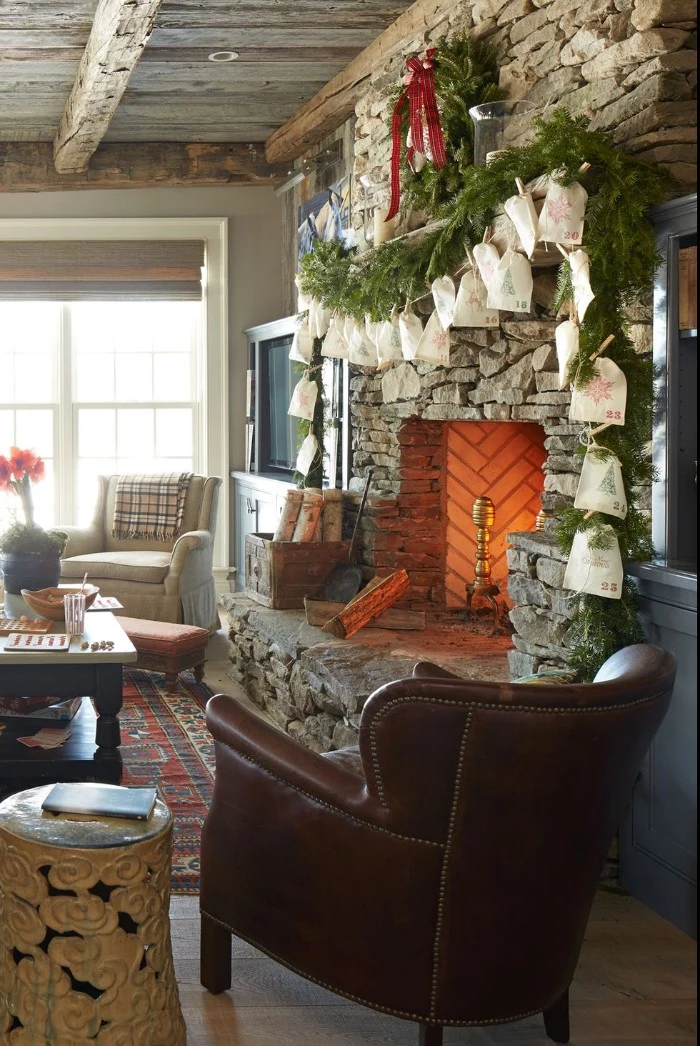 fireplace made of stone, decorated with fir branches, and an advent calendar, featuring cream paper bags, in a country chic living room