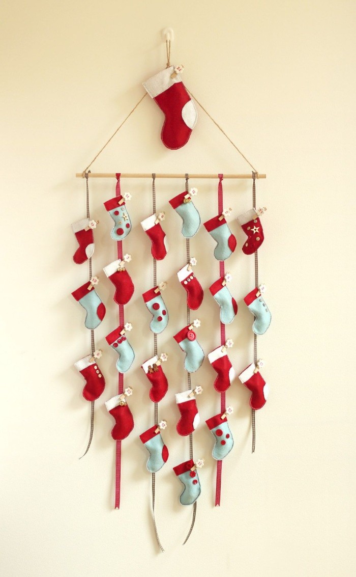 light blue and red, miniature stockings with white details, made from felt, attached to six pieces of string, tied to a small wooden pole, creative christmas countdown calendar, you can make yourself 