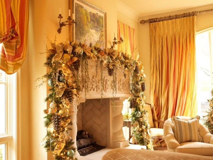 well lit rooom, with orange curtains, and a classic fireplace, decorated with a large garland, in green and gold, with baubles and pine cones, christmas fireplace ideas