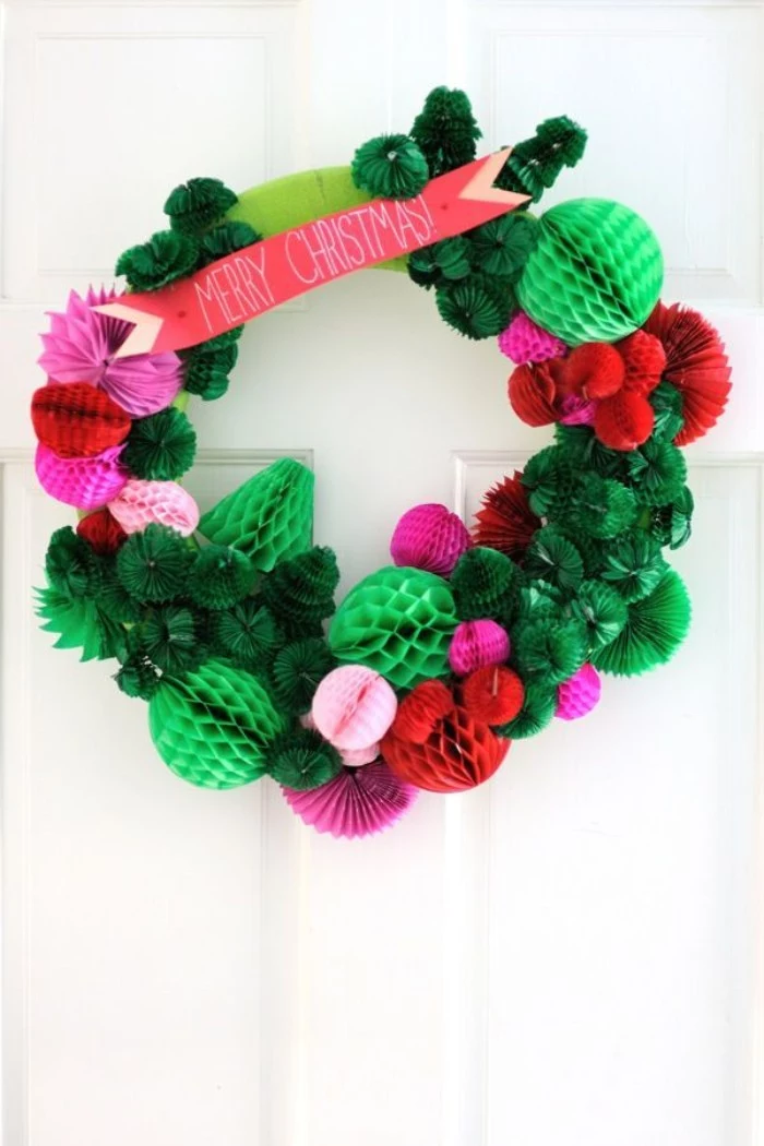 christmas wreath ideas, multiple paper shapes, in light and dark green, pink and red, stuck together to form a wreath, with a coral pink banner, reading merry christmas