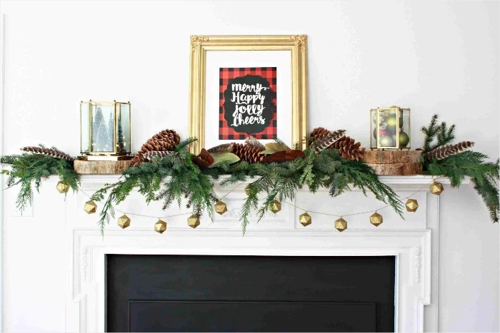 minimalistic christmas fireplace decoration, fir branches and pine cones, small garland with gold ornaments