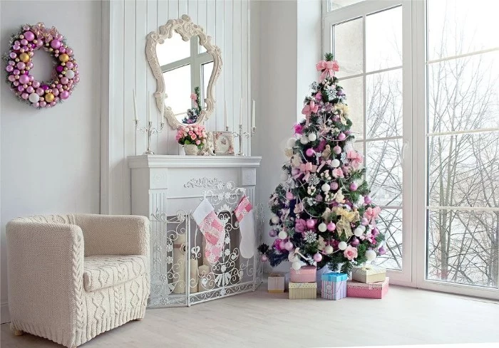 holiday images, bright room with large windows, white walls and a pale floor, containing a white fireplace, and a christmas tree, both decorated in gentle pink tones