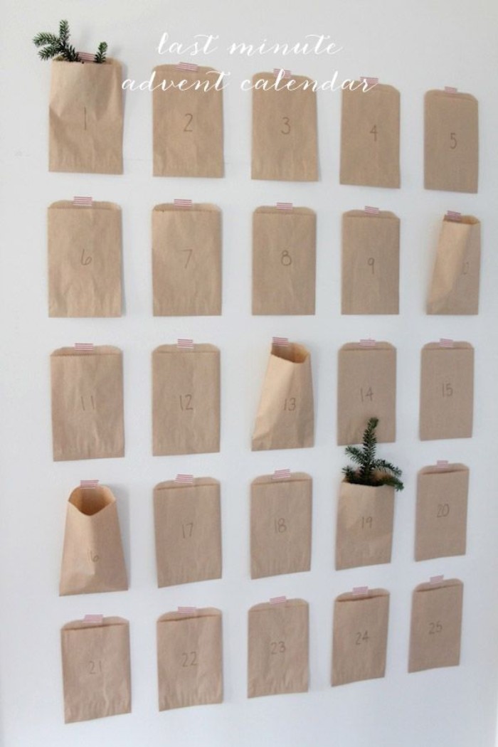 minimalistic advent calendar, made of 25 small, numbered beige paper bags, stuck to a white wall, each bag features a number, from 1 to 25