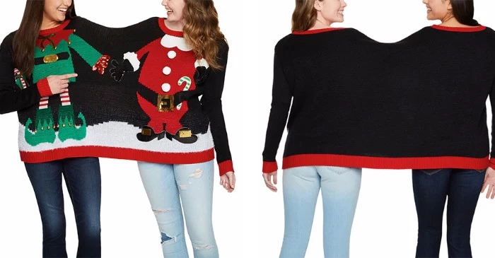 buddy jumper shared by two laughing girls, ugliest christmas sweater, in black with red trims, featuring an elf and a santa
