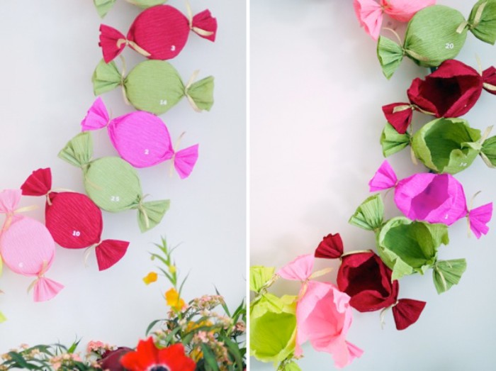 candy-shaped presents, made with tissue paper in different colors, forming a wreath, decorated with small, white number stickers, christmas advent calendar