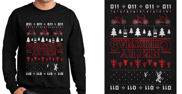 sweater inspired by the tv show stranger things, black with a christmas-like pattern, featuring bikes and xmas trees, walkie talkies and numbers, and the words mery christmas, turned upside down