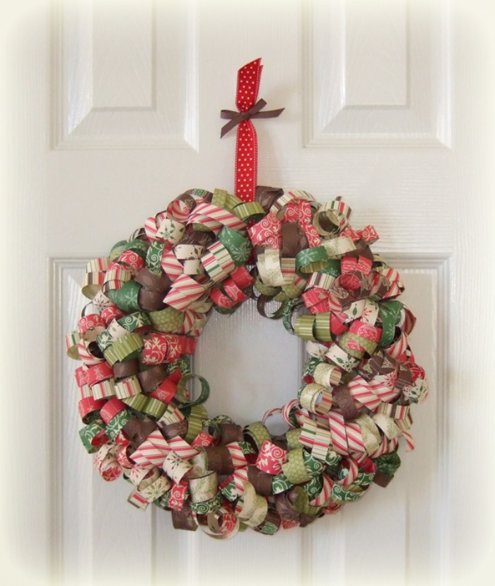 curled paper strips, in many different colors and patterns, stuck on a round frame, to form a christmas wreath, hanging on a white door, holiday wreaths
