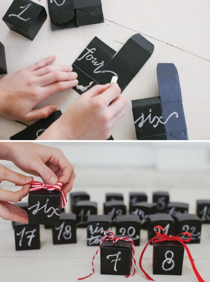 the word four, being written in white chalk, on a black piece of card, more pieces of black card nearby, diy advent calendar, next image shows several black boxes, with white numbers, and red ribbon bows