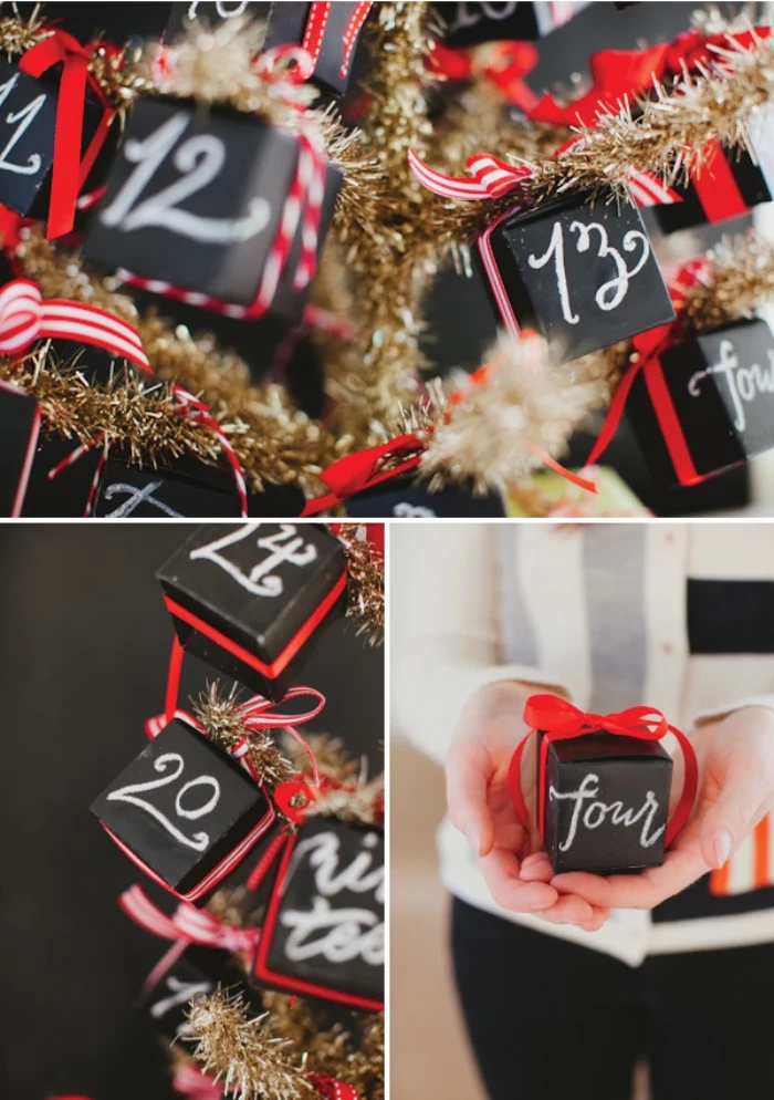close up of a gold, faux christmas tree, decorated with small, black cube-shaped boxes, decorated with numbers written in white chalk, and red ribbon tied in bows, diy advent calendar, hand holding one of the boxes