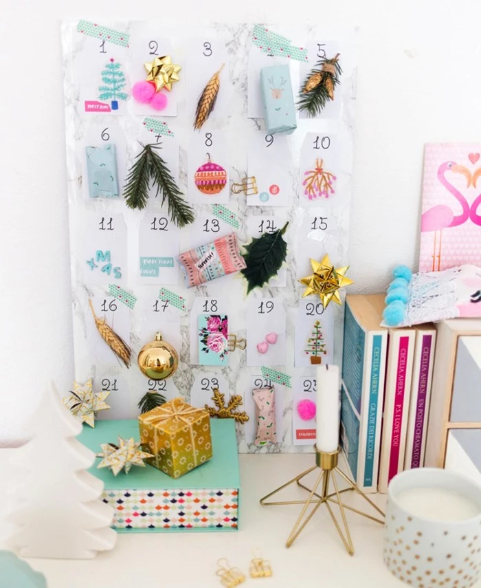 assortment of christmas ornaments, cards and little fir tree branches, stuck to 25 white pieces of paper, christmas countdown calendar, attached to a white board, with a pale grey marble pattern
