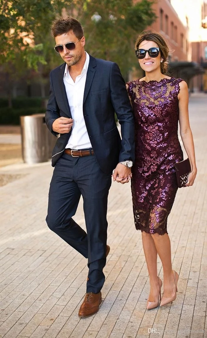 shiny purple midi dress, with lace details and sequins, worn by a smiling brunette woman, with sunglasses and nude beige shoes, walking hand in hand with a man, dressed in a navy suit, and a white shirt, cocktail attire for women