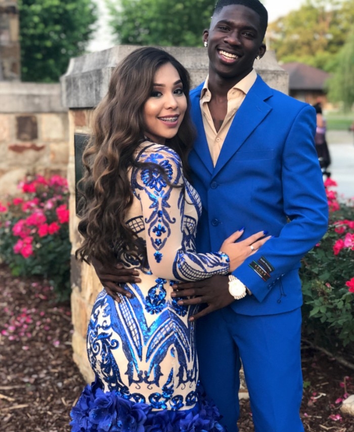 formal and semi formal wedding attire, couple dressed in complementary outfits, she is in a pale nude beige dress, with silky electric blue embroidery and frills, and he is wearing an electric blue suit, with a light beige shirt
