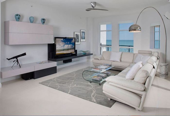 white walls, white corner sofa with light pink throw pillows, light grey carpet, home decor ideas for living room