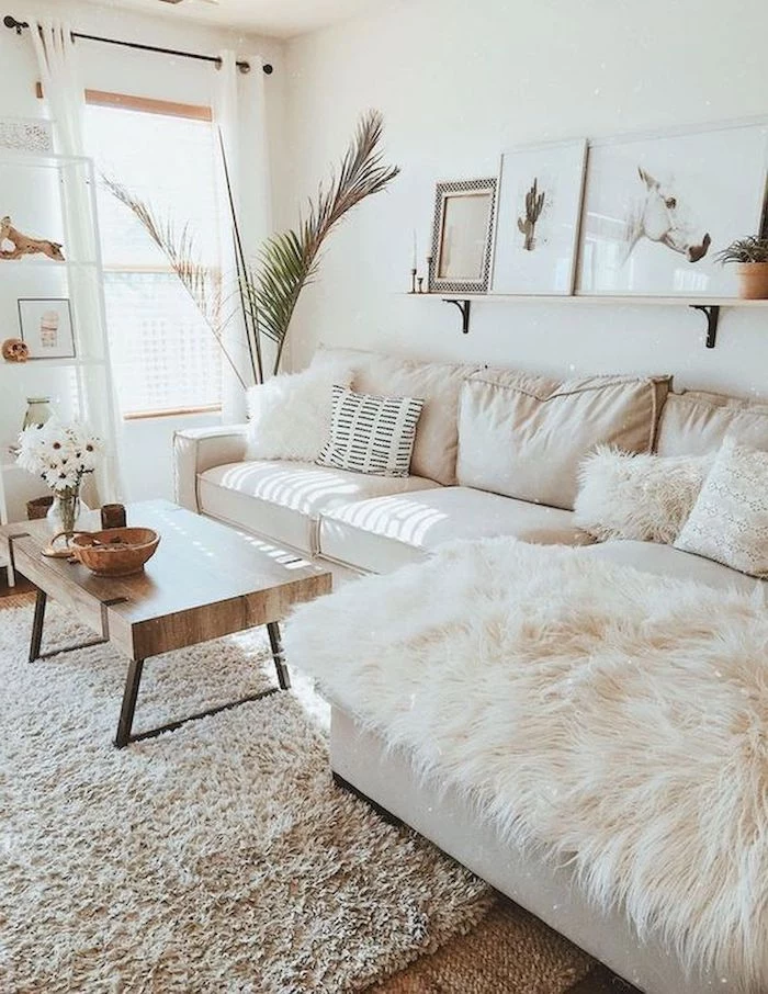 white walls, white corner sofa with white printed throw pillows, cream carpet, small wooden coffee table, small living room decorating ideas