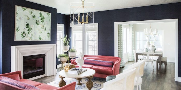 navy blue walls, pink sofas, wooden floor with a printed carpet, painting above the fireplace, modern contemporary design