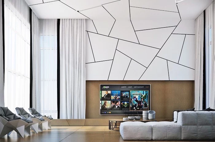 white geometrical wall and ceiling installation, grey corner couch, grey leather armchairs, accent wall ideas